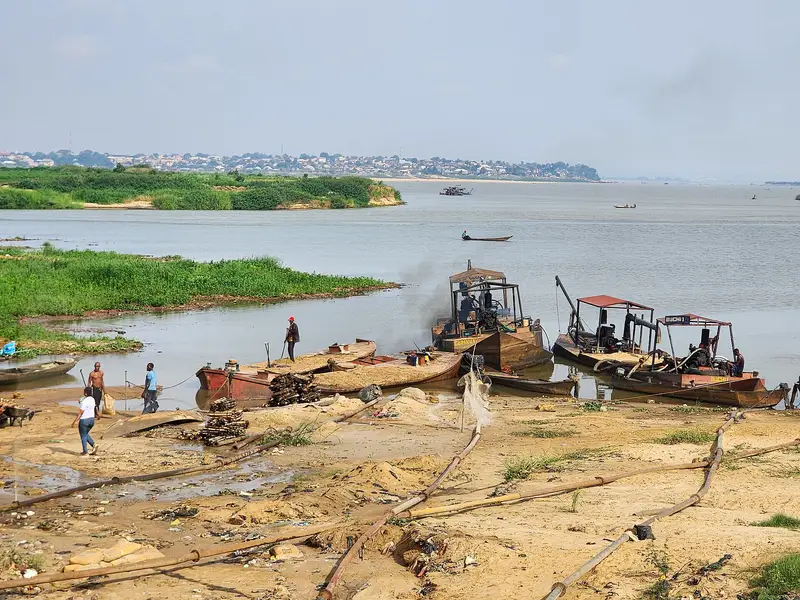 Sand being extracted from a river channel, with excavated banks visible